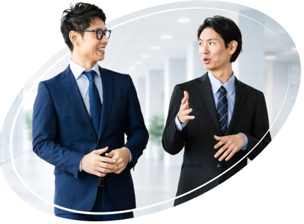 スーツ姿の男性二人が笑顔で会話している様子
