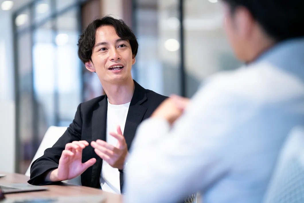 男性社員がオフィスで打ち合わせをしている様子